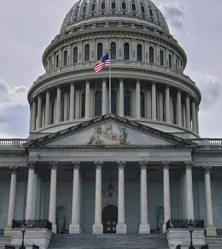 The image shows the U.S. Capitol Building with its iconic dome and American flag flying at half-staff against a cloudy sky.

The image of the U.S. Capitol Building, with the flag at half-staff, visually reinforces the post's message about U.S. legislative developments, symbolizing the governmental resistance and legislative tensions referenced regarding the Clarity law and the pushback from banks and trusts.