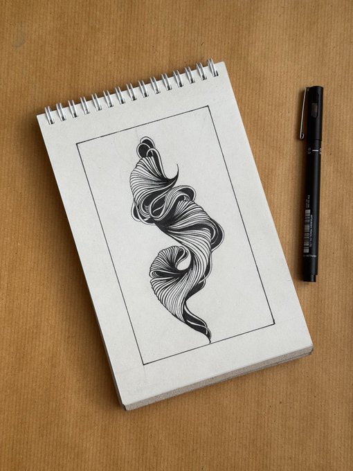A spiral-bound sketchbook lies open on a tan surface, displaying an abstract flowing black ink line drawing, accompanied by a black fineliner pen.