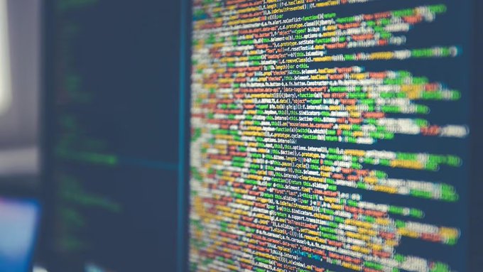 A close-up view of computer code displayed on a monitor, featuring colorful syntax highlighting typical of programming environments.