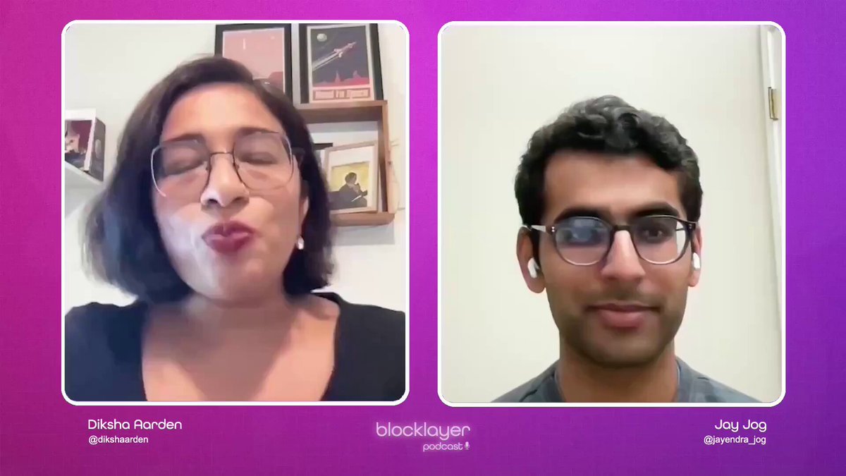 The image shows two people having a video call using their computer screens as the display. The person on the left side of the screen has a black shirt, while the other person on the right side wears glasses. They are both looking at each other with smiles on their faces, indicating that they are enjoying the conversation or sharing something amusing.