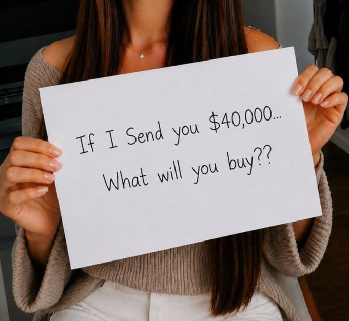 A woman in a tan off-the-shoulder sweater holds up a white sign that reads "If I Send you $40,000... What will you buy??" The image directly illustrates the post's prompt, asking followers to share honestly what they would purchase with $40,000 in exchange for the chance to receive the $ANSEM cryptocurrency.