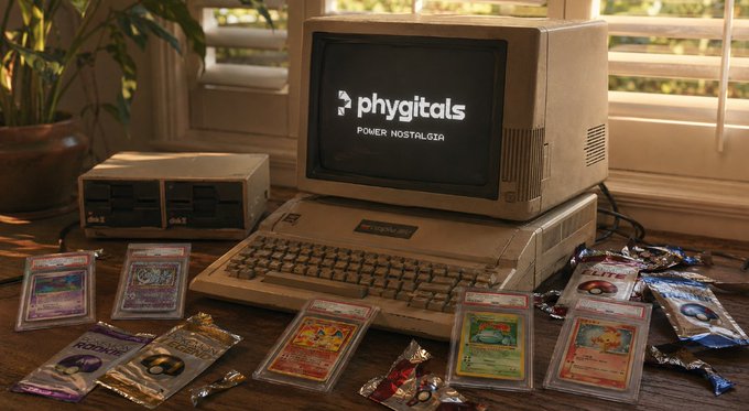 A vintage computer setup with a CRT monitor displaying 'phygitals POWER NOSTALGIA', accompanied by a keyboard and scattered Pokemon trading cards and booster packs.
