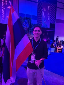 A person holds a large flag in a venue with "Devcon" and "Bangkok" visible in the background, referencing Devcon SEA. The image reflects the post, which announces the end of the author's role at the Ethereum Foundation, expressing mixed emotions of sadness and love for the Ethereum community at this conference.