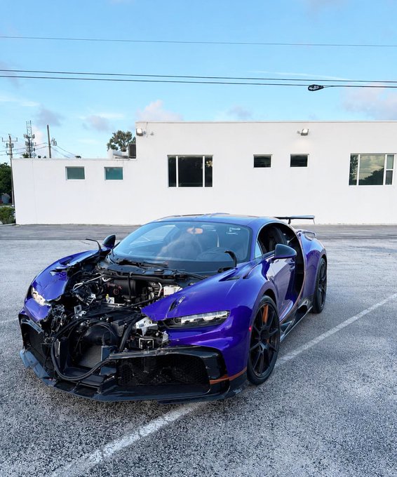 A purple Bugatti Chiron Pur Sport with severe front-end damage and a missing hood sits in a parking lot, humorously illustrating a memecoin trader's "brutal" financial losses on their prized luxury asset.