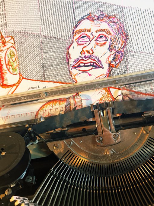 A close-up of a vintage typewriter with typed paper showing a colorful hand-drawn portrait labeled 'Angel #1'.