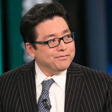 The image shows a man dressed in business attire with glasses standing next to a blue wall backdrop with a green curtain. The text reads "INTEL: Tom Lee's BitMine now faces a $10.16B unrealized loss on 5.42M Bitcoin as Ethereum trades near $1,600". The context suggests that the man is attending an event related to cryptocurrency or virtual currency and discussing its potential value in relation to Bitcoin.