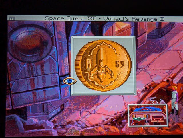 A screenshot from the video game 'Space Quest XII - Vohaul's Revenge II' showing a gold coin depicting a figure in a pointed hat with the number 59.