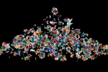 The image features an abstract art piece composed of numerous small flowers, each with different colors such as red, blue, green, yellow, and purple. The flowers are scattered across a black background, creating a visually striking contrast between the vibrant colors and the dark backdrop. The arrangement of these colorful flowers appears to be random yet harmonious, giving it an impressionistic feel.