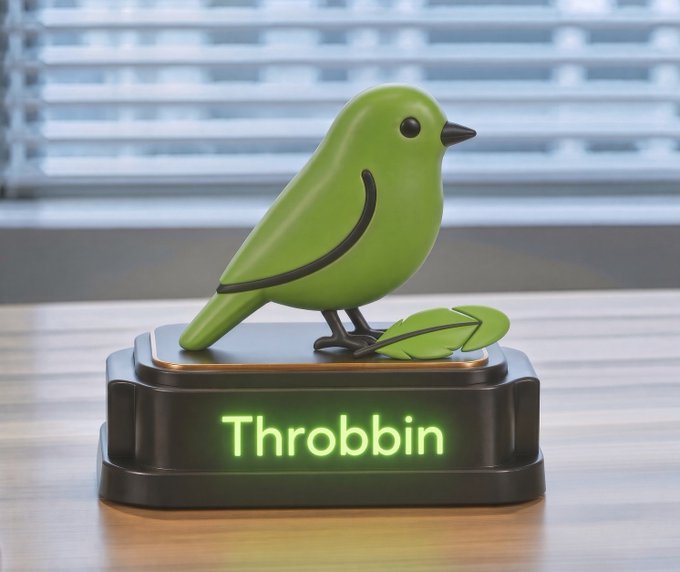 A green stylized bird figurine displayed on a dark pedestal labeled 'Throbbin' in glowing green text, set on a wooden surface near a window with blinds.