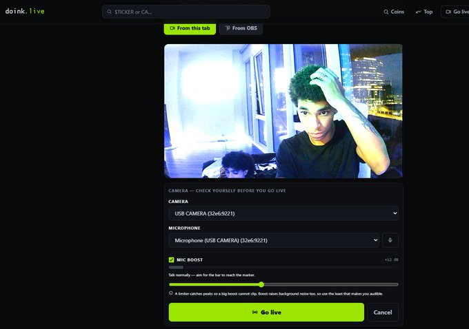 A doink.live streaming setup screen displays a webcam preview of a young man with curly hair scratching his head, with camera and microphone settings visible including 'USB CAMERA (32e69221)' and a green 'Go Live' button.