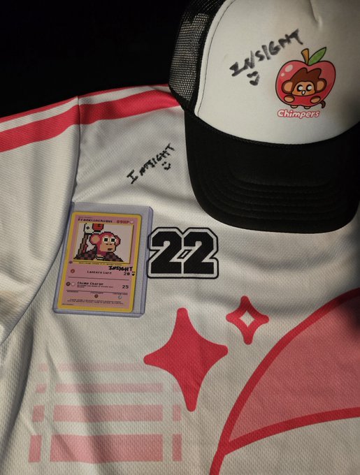 A white and red sports jersey with the number 22, a black and white trucker hat with an apple-monkey 'Chimpers' logo and 'INSIGHT' text, and a custom Pokemon-style trading card are arranged together.