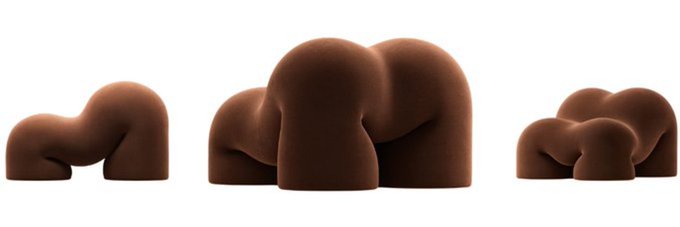 Three groups of rounded, brown abstract sculptures with smooth, blob-like forms are displayed against a white background, their playful, organic shapes evoking the lighthearted, cheeky aesthetic implied by the Solana token name "$NAKED" added by a community member as a banner image on Moby.
