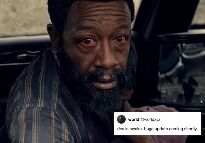 A close-up of a bearded man with an emotional expression in what appears to be a car, with a tweet overlay from 'world' (@worldxyz) that reads 'dev is awake. huge update coming shortly'.