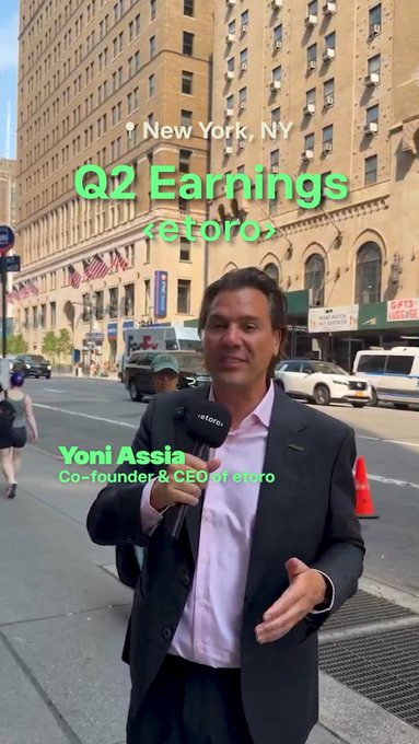 Yoni Assia, Co-founder & CEO of eToro, stands on a New York City street holding an eToro microphone, with on-screen text reading "New York, NY" and "Q2 Earnings (eToro)" — visually introducing his Q2 earnings update highlighting 9% growth in Net Contribution and Adjusted EBITDA, 18% growth in Funded Accounts, and new AI trading and crypto expansions.