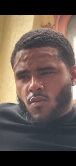 Close-up portrait of a bearded man looking downward with a serious expression.
