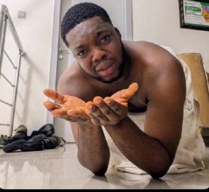 A shirtless man kneels on the floor with his hands outstretched in a pleading gesture, smiling sheepishly as if begging for a favor. The image humorously illustrates the post's request for the community to "vouch" for @Monothiez, with the person promising to share a percentage of "the dust" (likely cryptocurrency profits) in return.
