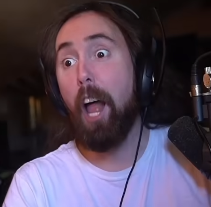 A long-haired, bearded man wearing headphones and a white t-shirt makes an exaggerated shocked expression with wide eyes and an open mouth, sitting in front of a microphone. His stunned reaction mirrors the post's humor about the realization that Artisan will make off-ramping obsolete, as if he's processing a mind-blowing revelation.