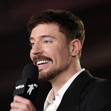 A smiling man in a dark suit holds a microphone while being interviewed, with text "PREA" and an MTV logo visible on the microphone. This appears to be MrBeast, the popular YouTuber, though the post makes suspicious claims about a "$BEAST" token presale that should be treated with extreme caution, as celebrity crypto token promotions of this nature are commonly associated with scams.