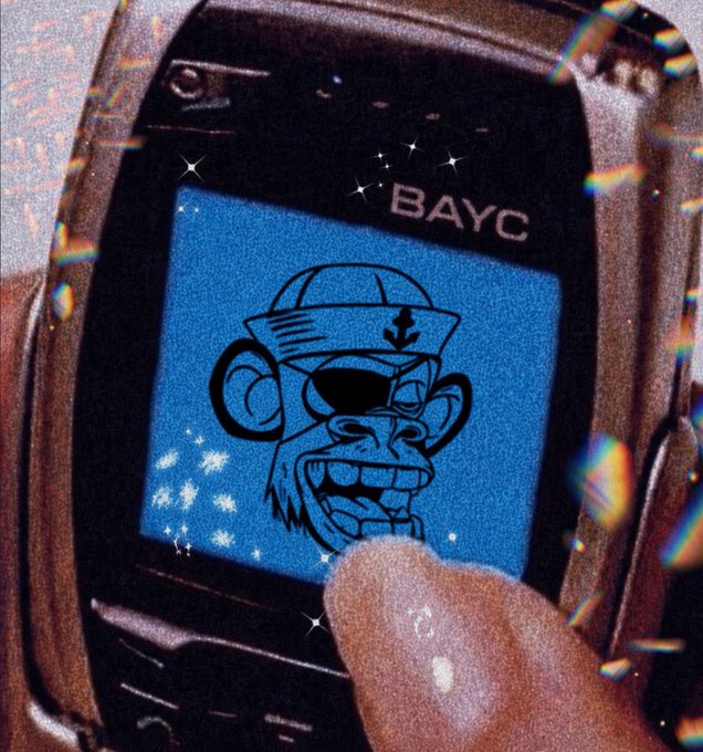 The image features a cell phone with a cartoon monkey graphic displayed on its screen, which appears to be a playful or humorous design. The text "Bored Ape Yacht Club" is also present in the image. This combination of elements suggests that the image might be related to an advertisement for a club or event called "Bored Ape Yacht Club", where people can enjoy various activities and entertainment options, including watching cartoons featuring monkeys on their cell phones.