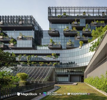 A modern multi-story glass office building with numerous balconies featuring plants, with logos at the bottom reading 'MagicBox', 'FCLOR PRODUCTION', and 'superbeam'.