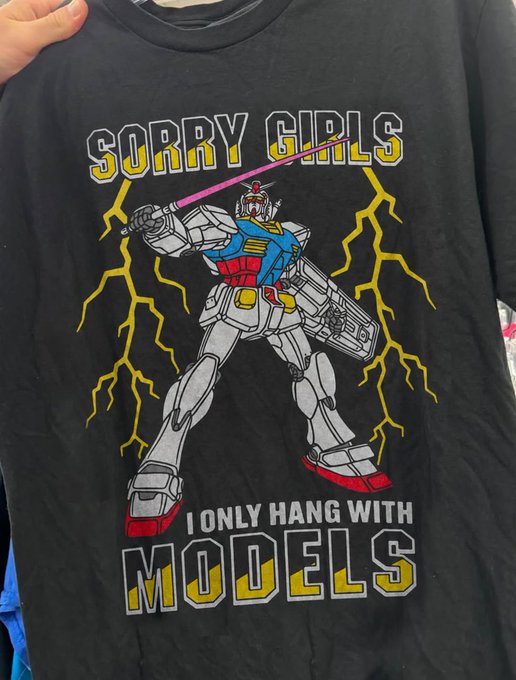 Black t-shirt featuring a Gundam-style mecha robot wielding a pink lightsaber amid yellow lightning bolts, with text reading 'SORRY GIRLS' above and 'I ONLY HANG WITH MODELS' below.