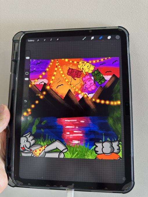 A tablet displaying a digital painting in a gallery app, featuring a cat character lounging by water under string lights, mountains, and smiling clouds at sunset.