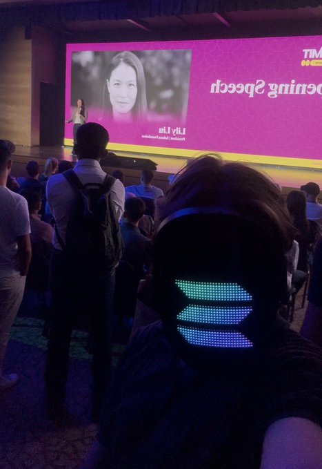 The image shows attendees at a Solana Singapore event, with a presenter on stage in front of a screen displaying the words "Speeding Speed" alongside a portrait. The accompanying "Gm Solana Singapore!" post relates to the scene by highlighting the community gathering of crypto/blockchain enthusiasts at this conference.