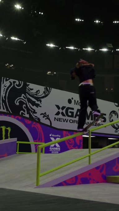 A skateboarder grinds down a green rail at the X Games New Orleans, with visible "Monster," "XGAMES," and "2026" branding on the ramp backdrop, capturing the high-stakes energy of a major competition weekend.