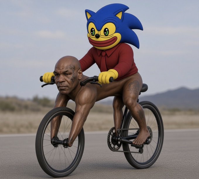 The surreal image shows Mike Tyson (or a hyper-realistic likeness) crouched in an unusual position as the "front" of a bicycle, while a cartoonish Sonic the Hedgehog character in a red shirt sits behind him pedaling. The bizarre, meme-like composition pairs "gm" (crypto/internet slang for "good morning") with this absurd, attention-grabbing visual as a humorous morning greeting.