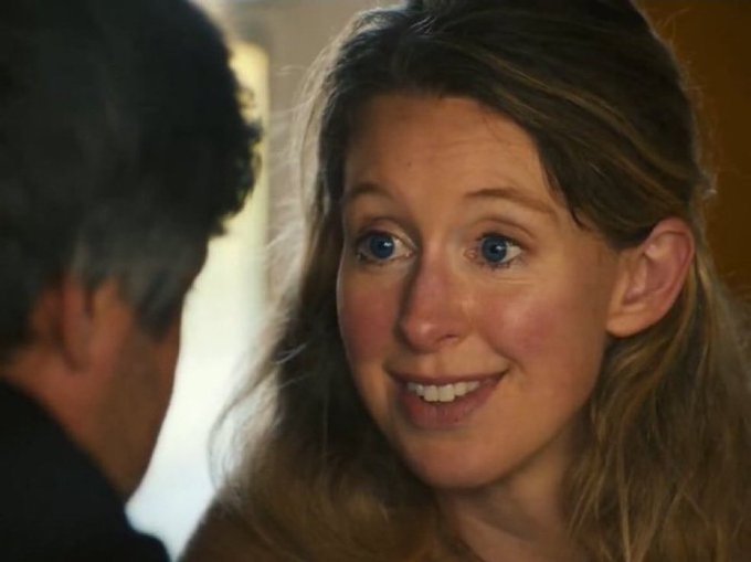A woman smiles at a man (only the back of his head visible), her expression wide-eyed and enthusiastic, as if she's happily agreeing to something. The image humorously captures the gullible excitement referenced in the caption about being convinced to invest in a rug-pull crypto scheme.