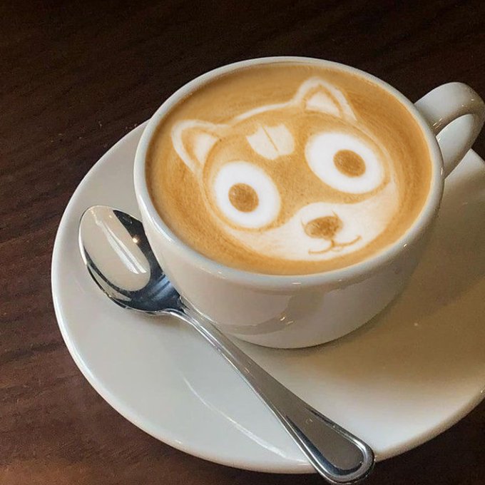 A cappuccino in a white cup features intricate latte art of a Shiba Inu dog, connecting to the post's reference to the $NEIRO meme coin, which features a similar Shiba Inu as its mascot on the Ethereum blockchain.