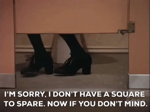 The image shows a person's feet peeking out from behind a door with a message written above them that reads "I'm sorry, I don't have a square pair now if you don't mind". The text appears to be in a foreign language or script and is not related to the main subject of the photo.