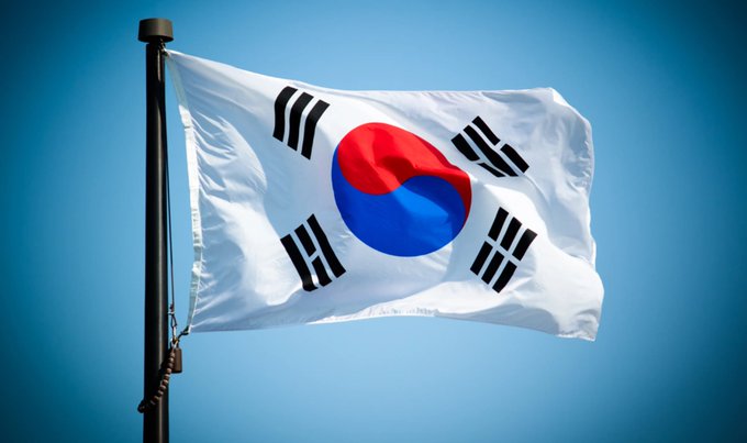 The South Korean flag waves against a clear blue sky, symbolizing the country's embrace of Ripple for cross-border payments through Jeonbuk Bank. This image highlights South Korea's proactive approach to financial innovation in contrast to regulatory debates in the West.