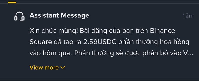 A dark UI notification card titled 'Assistant Message' from 12m ago, with Vietnamese text starting 'Xin chúc mừng! Bài đăng của bạn trên Binance Square đã tạo ra 2.59USDC...' and a yellow 'View more' link.
