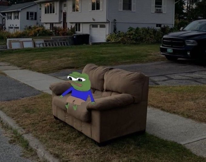 A Pepe the Frog meme depicting the cartoon character sitting on a brown couch that has been placed outside on a residential lawn near a street, with a house and dark pickup truck in the background.