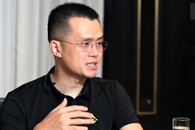 In this image, a man wearing glasses is sitting at a table with his hands up, possibly gesturing or making a point during a conversation. The background features a window that allows natural light into the room, creating an atmosphere of openness and comfort. A glass of water can be seen on the table next to the man, suggesting that he might have been engaged in a discussion about financial matters or market trends.

The image also contains text that reads "CZ - Binance said: The FOMO is just getting started. $XRP". This could indicate that the conversation revolves around cryptocurrency and its potential impact on the market.