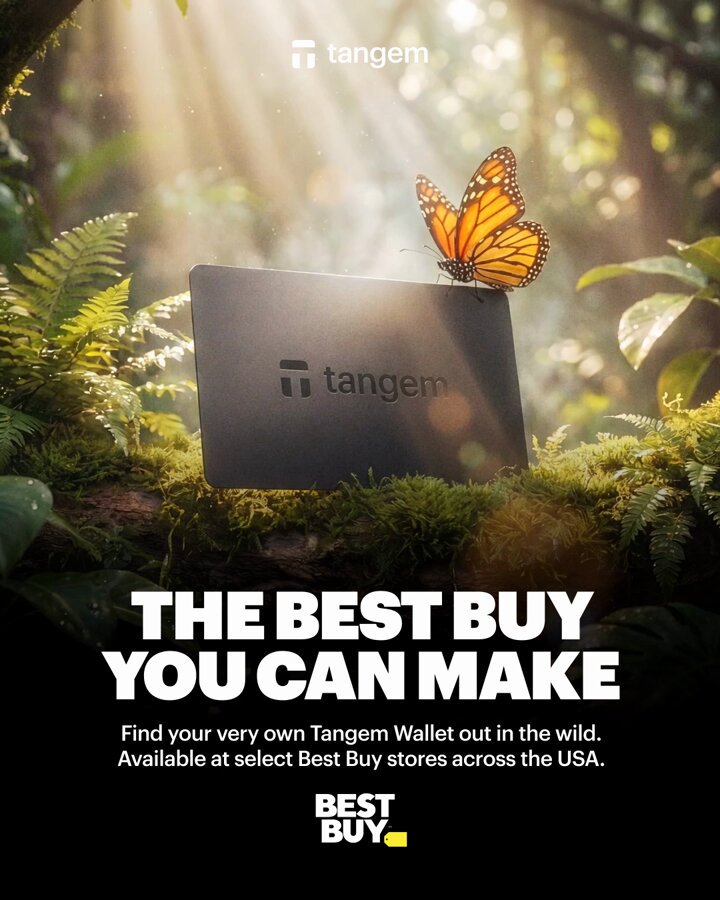 The image features a butterfly perched on top of a black Tangem wallet, which is placed on a bed of moss. The background of the image is filled with trees and foliage, creating an outdoor setting that complements the wallet's design. The text in the image reads "The best buy you can make", indicating that the wallet is available for purchase at Best Buy stores across the United States.