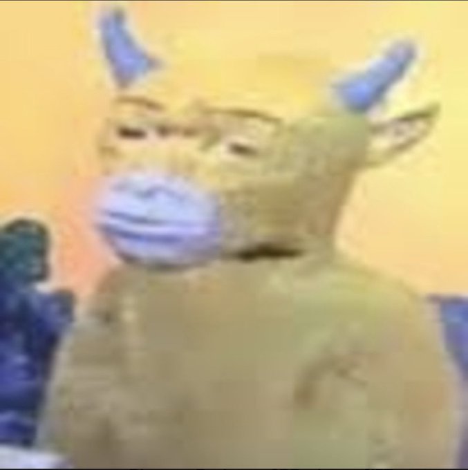 A blurry, low-resolution image of a green horned character with a large purple snout, possibly from a children’s television show or animation.