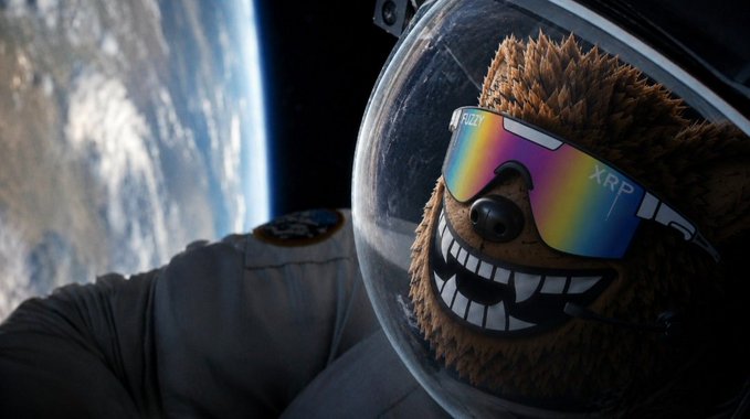 A furry brown bear character wearing rainbow-tinted sunglasses labeled "XRP" and a space helmet floats in orbit above Earth, creating a humorous "moonclub" scene that visually matches the post's playful $FUZZY rocket-to-the-moon narrative. The grinning bear in astronaut gear embodies the meme's cosmic celebration of the cryptocurrency community.