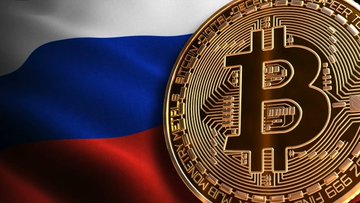 A golden Bitcoin coin rests against the Russian tricolor flag, symbolizing Russia's push to establish a legal framework for digital assets while U.S. crypto legislation like the CLARITY Act remains stalled in Congress since 2023.