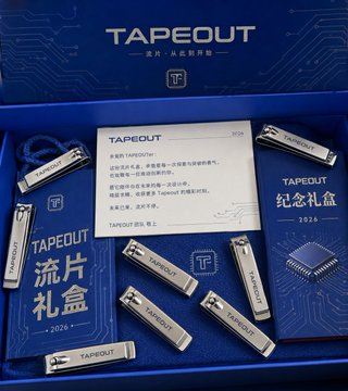 A blue 'TAPEOUT' branded 2024 commemorative gift box is open, displaying metal USB drives, a card, and informational booklets inside.