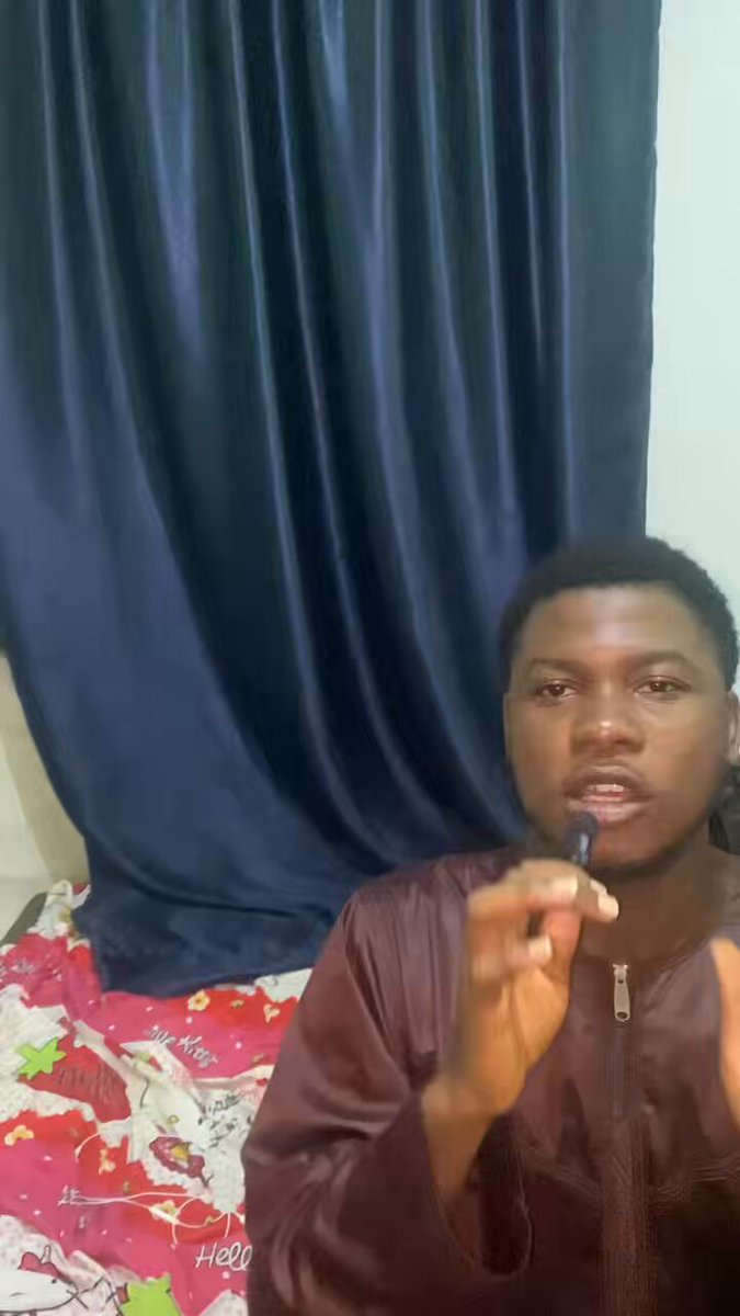 The image features a man wearing a brown jacket, holding a black object (possibly a camera or microphone) while standing against a blue curtain backdrop. The caption of the image reads "From Nigeria You can try AI and earn from it!!! Just by recording yourself doing your daily activities... Watch this video to understand better Fill this form to get in!! @RootLens_sol is the future". This suggests that the man might be promoting an AI or machine learning project, possibly related to speech recognition or natural language processing.
