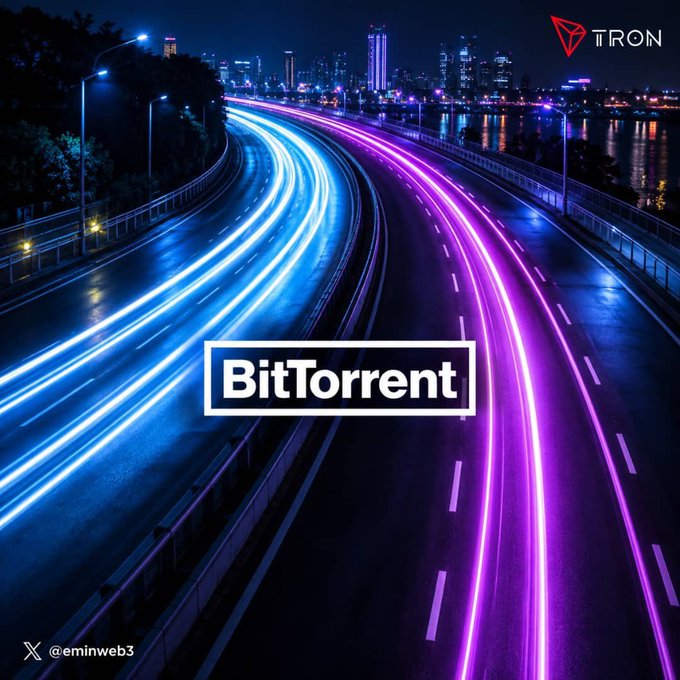 A nighttime cityscape showing light trails on a highway with neon blue and magenta streaks, featuring a prominent 'BitTorrent' logo in the center, a 'TRON' logo in the upper right corner, and the handle '@eminweb3' in the bottom left.