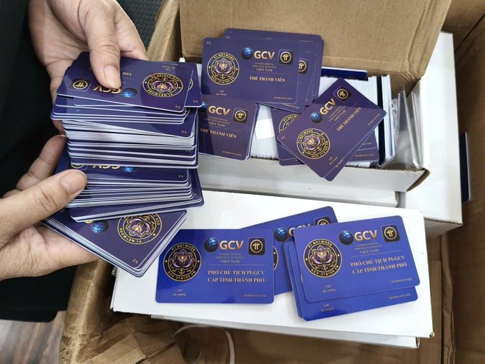 The image shows a person holding a stack of blue membership/ID cards labeled "GCV" with "THE THANH VIEN" and Vietnamese text reading "PHO CHU TICH GCV CẤP TỈNH/THÀNH PHỐ," suggesting a local vice chairman role in an organization, being sorted from a cardboard box. The caption appears unrelated to the image, as the cards relate to a Vietnamese government or organizational affiliation (GCV), not Pi Network cryptocurrency or China.