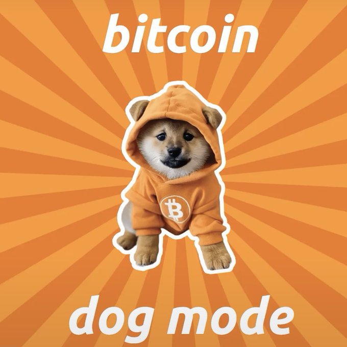 The image shows a Shiba Inu dog wearing an orange hoodie featuring the Bitcoin "₿" logo, set against an orange sunburst background, with the text "bitcoin" at the top and "dog mode" at the bottom. It illustrates the concept of "$DOG Mode," an alternative Bitcoin software client proposed by LeonidasNFT, playfully merging Bitcoin branding with Dogecoin-style meme aesthetics.