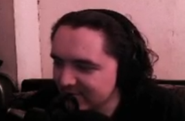 A man with shoulder-length dark hair sits in front of a microphone in a dimly lit room with pinkish lighting, appearing to host a livestream. The image captures the streamer during the "Opening 27 Bonuses" live event on @yeet, where viewers are encouraged to drop SOL wallets to win prizes on kick.com/jerzynft.