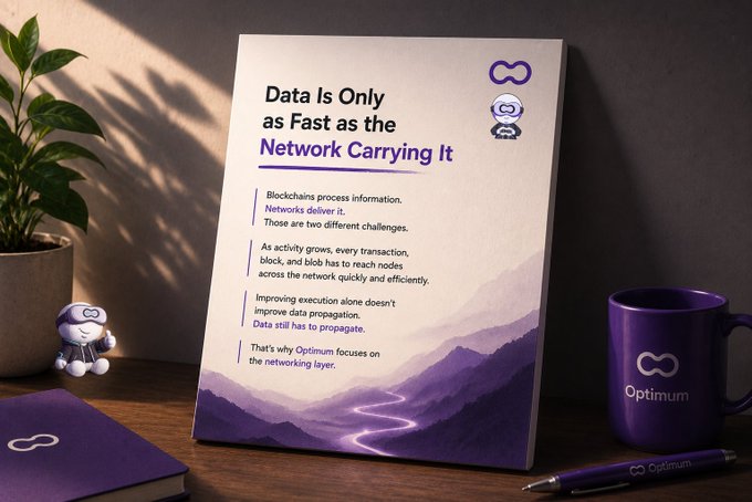 A desk scene featuring a poster with the Optimum logo reading 'Data Is Only as Fast as the Network Carrying It,' accompanied by a purple Optimum mug, notebook, and pen, with a small robot figurine.