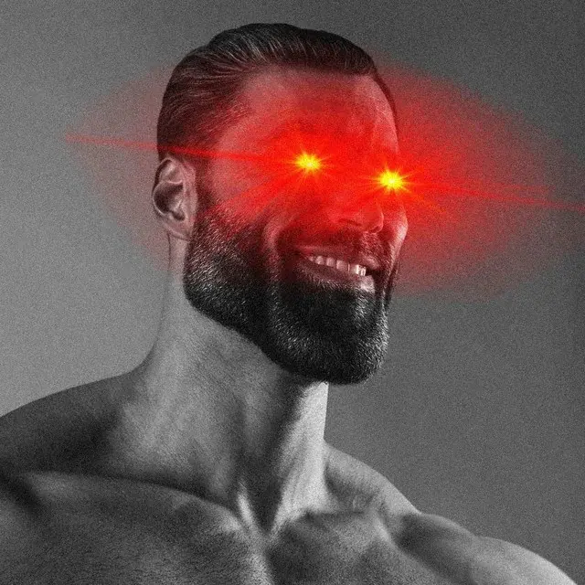 An edited photo of a smiling, bearded man whose eyes have been replaced with glowing red laser beams against a gray background.