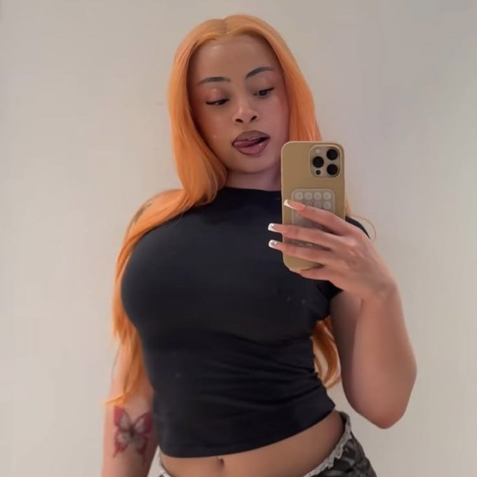 The image shows a young woman with long orange hair taking a mirror selfie in a black crop top, holding a gold phone case. The post's question "One night with her or 5 BTC?" uses the photo as a provocative prompt, weighing the value of her company against the price of 5 Bitcoin (approximately $345,000+).