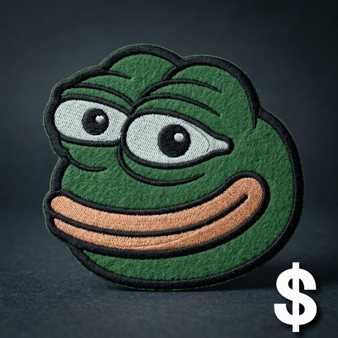 A green embroidered patch of the Pepe the Frog meme character with a large smile, set against a dark background with a white dollar sign symbol in the corner.